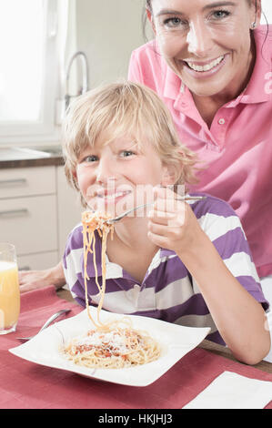 Portrait of a Boy eating spaghetti avec sa mère,Bavière, Allemagne Banque D'Images
