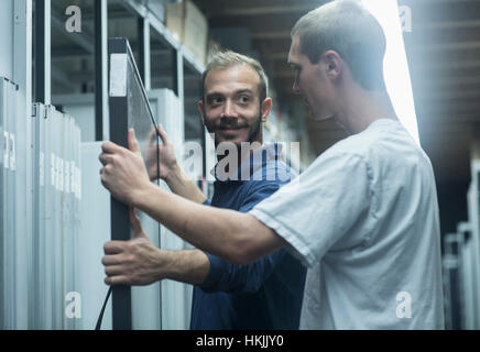 Les travailleurs du magasin travaillant dans un entrepôt de distribution, Freiburg im Breisgau, Bade-Wurtemberg, Allemagne Banque D'Images