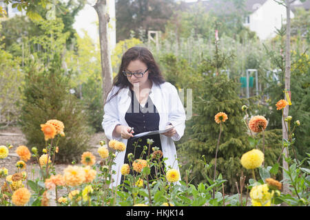 Female scientist inspection à fleurs,à effet de Freiburg im Breisgau, Freiburg im Breisgau, Allemagne Banque D'Images