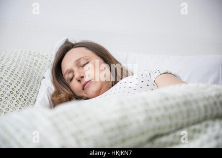 Pregnant woman sleeping in bed, Munich, Bavière, Allemagne Banque D'Images