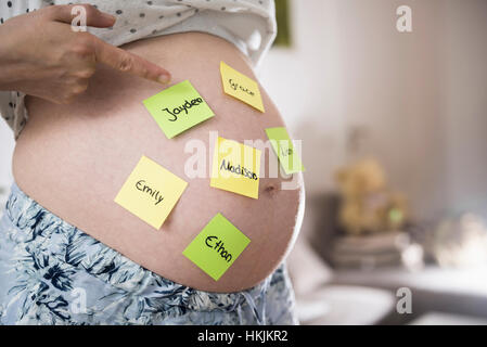 Femme enceinte avec des noms de bébé sur le ventre, Munich, Bavière, Allemagne Banque D'Images