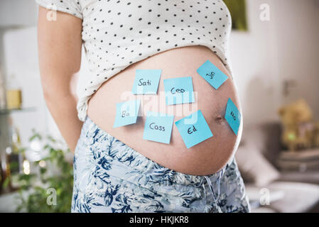 Femme enceinte avec des noms de bébé sur le ventre, Munich, Bavière, Allemagne Banque D'Images