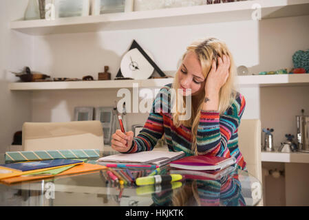 Jeune étudiant à faire leurs devoirs dans le salon, Bavière, Allemagne Banque D'Images