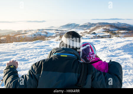 Couple aimant à la recherche à l'horizon des montagnes enneigées Banque D'Images