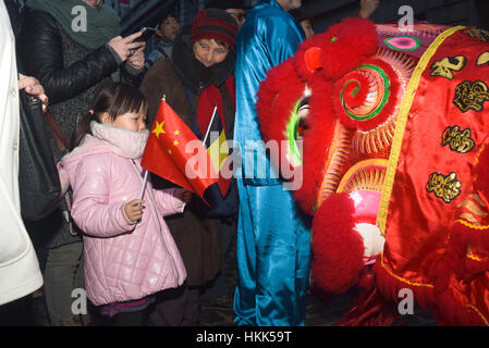 Bruxelles, Belgique. 28 janvier, 2017. Un dragon chinois fait peur un enfant avec un drapeau chinois au défilé du Nouvel An chinois à Bruxelles. Credit : Frederik Sadones/Pacific Press/Alamy Live News Banque D'Images