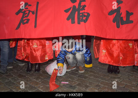 Bruxelles, Belgique. 28 janvier, 2017. Un enfant joue avec un drapeau chinois au défilé du Nouvel An chinois à Bruxelles. Credit : Frederik Sadones/Pacific Press/Alamy Live News Banque D'Images