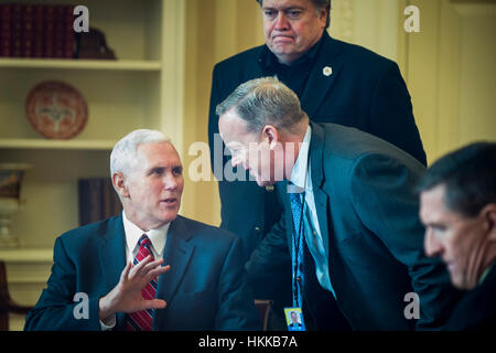 Washington DC, USA. 28 janvier, 2017. United States Vice-président Mike Pence parle avec Secrétaire de presse de la Maison Blanche Sean Spicer comme président Donald Trump parle avec le président de la Russie, Vladimir Poutine, sur le téléphone dans le bureau ovale à Washington, DC. L'appel a été l'un des cinq appels avec des dirigeants étrangers prévu pour samedi. Stratège en chef Stephen K. Bannon et conseiller pour la sécurité nationale Michael Flynn étaient également dans la salle. Credit : MediaPunch Inc/Alamy Live News Banque D'Images