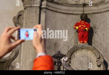 Bruxelles, Belgique. 28 janvier, 2017. Les gens prennent des photos de la facade 'Manneken Pis' habillé en costume traditionnel chinois pour célébrer le Nouvel An lunaire chinois à Bruxelles, capitale de la Belgique, le 28 janvier 2017. Credit : Gong Bing/Xinhua/Alamy Live News Banque D'Images