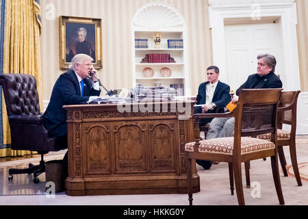 Washington DC, USA. 28 janvier 2017. Le Conseiller pour la sécurité nationale Michael Flynn et conseiller principal au président Steve Bannon, s'asseoir à proximité, ainsi que le Président des Etats-Unis, Donald Trump parle au téléphone avec le Premier Ministre de l'Australie, Malcolm Turnbull dans le bureau ovale le 28 janvier 2017 à Washington, DC, l'appel a été l'un des cinq appels avec des dirigeants étrangers prévu pour samedi. Dpa : Crédit photo alliance/Alamy Live News Banque D'Images