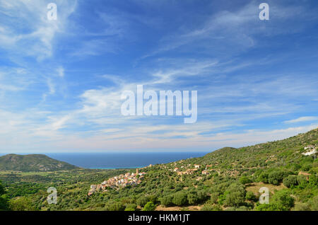 La Balagne est aussi appelé le jardin de la Corse. Au premier plan il y a une colline couverte de maguis et un petit village. Il y a une plaine fertile Banque D'Images