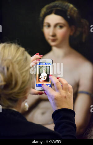 Rome. L'Italie. Visiteur en utilisant un téléphone cellulaire pour prendre une photo de la Fonarina par Rapahael dans la Galleria Nazionale d'Arte Antica, Palazzo Barberini. Banque D'Images