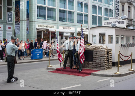 Berlin. L'Allemagne. Un touriste a pris en photo avec les acteurs habillés comme des garde-frontières à Checkpoint Charlie. Banque D'Images