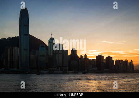 Silhouette de gratte-ciel et autres bâtiments sur l'île de Hong Kong à Hong Kong au coucher du soleil. Vue de la station de métro Tsim Sha Tsui, Kowloon. Banque D'Images