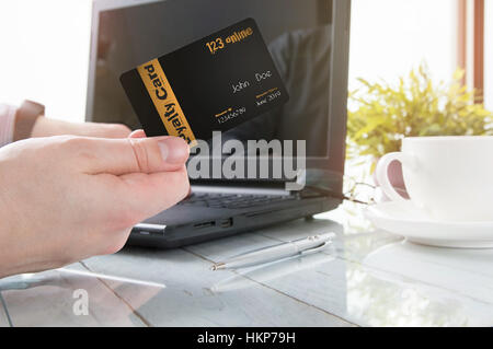 L'homme est maintenant une carte de fidélité tout en travail de bureau Banque D'Images