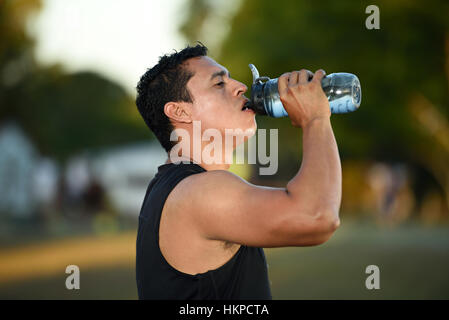 Sport homme boire de l'eau après entraînement in park Banque D'Images