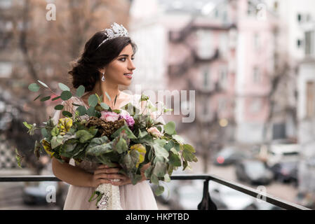 Mariée avec un bouquet de fleurs sur le balcon Banque D'Images