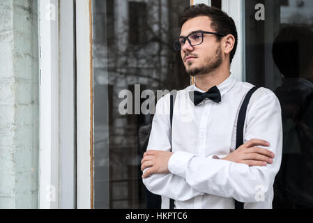 Groom smiling en chemise blanche près de la fenêtre Banque D'Images