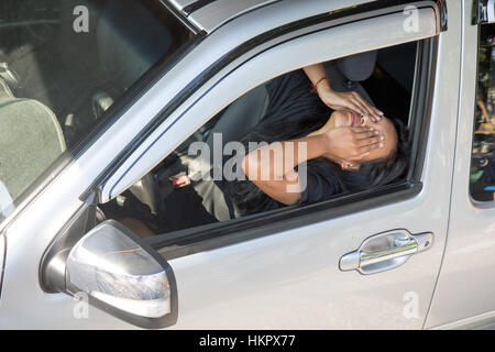 Femme endormie de fatigue au volant d'une voiture. Femme malheureuse dans la voiture peu après l'accident. Banque D'Images