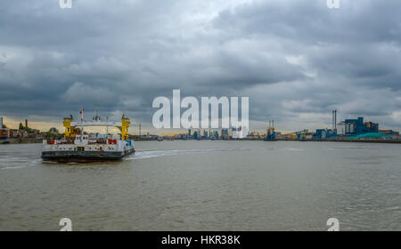 Traversée en ferry de Woolwich la Tamise. Shot de la Woolwich ferry traversant la Tamise sur un jour de tempête au coucher du soleil. Banque D'Images