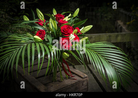 Roses rouges, des lys et des fleurs de palmier Banque D'Images