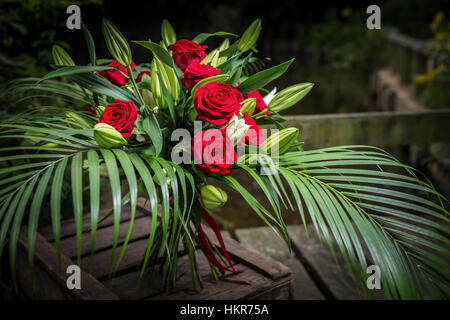 Roses rouges, des lys et des fleurs de palmier Banque D'Images