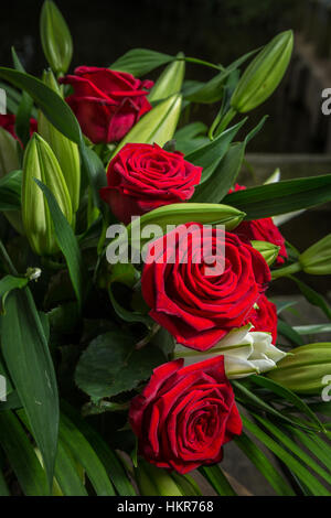 Roses rouges, des lys et des fleurs de palmier Banque D'Images