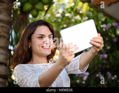 Fille hispanique prendre avec palm selfies sur fond vert Banque D'Images