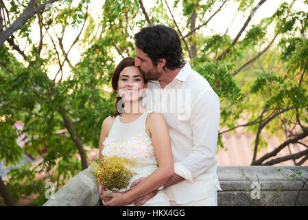 Groom kissing bride coucher du soleil sur fond clair Banque D'Images