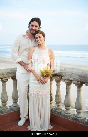 Heureux mariage pose smiling couple sur fond de mer Banque D'Images