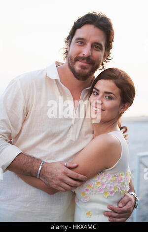 Portrait de hugging couple pendant le coucher du soleil sur la plage Banque D'Images