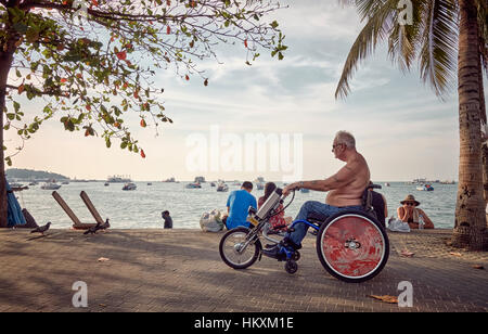 Transports mobilité pour un homme handicapé dans son fauteuil roulant Banque D'Images