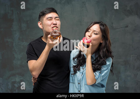 Jeune couple asiatique aiment manger des patates donut coloré Banque D'Images