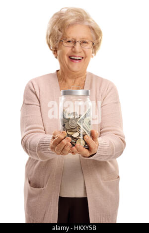 Heureux mature woman holding un bocal rempli d'argent isolé sur fond blanc Banque D'Images