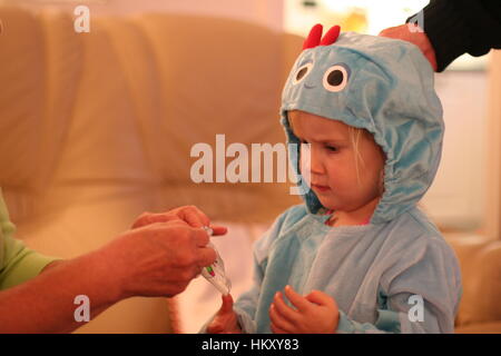 Petite fille, enfant habillé en safari Piggle, dans la nuit, portant un costume de jardin en velours bleu à capuche onesie costume, concept de la petite enfance, dressup, Banque D'Images