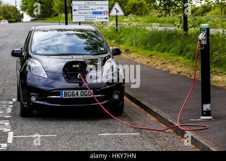 Location de vélos. La Nissan LEAF voiture garée sur le bord de la route à partir d'une charge publique d'un point de recharge. Banque D'Images