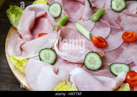 Bac alimentaire avec de délicieux morceaux de salami, de jambon en tranche, tomates, salade et légumes - plateau de viande avec la sélection Banque D'Images