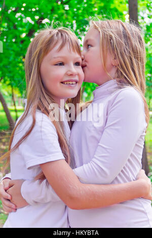 Photo de deux jeunes filles en été chuchotée smiling Banque D'Images