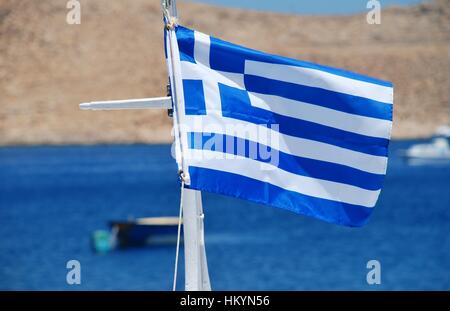 Le drapeau national de la Grèce volant à Emborio Harbour sur l'île grecque de Halki. Banque D'Images