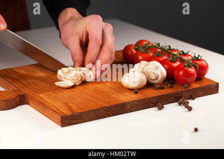 Champignons tranchés placé sur une planche en bois avec des tas de tomates. Suivre un régime de vie sain et concept Banque D'Images