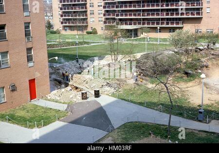 Un groupe de jeunes Afro-américains et caucasiens recueillir parmi des débris sur la pelouse d'un projet de logement dans le Bronx, New York City, New York, 1976. Banque D'Images