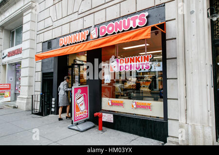 Une femme marche dans un Dunkin Donuts store sur West 72 Street à Manhattan. Banque D'Images