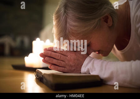 Hauts femme en prière, les mains jointes sur sa Bible. Banque D'Images