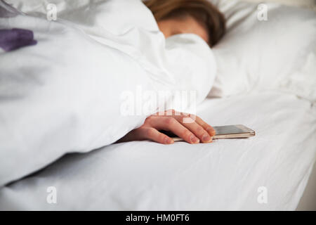 Femme au lit avec smarthphone Banque D'Images