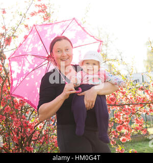 Maman et bébé en rose. Sourires heureux Banque D'Images