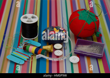 Kit de couture colorés sur fond de coton à rayures broches boutons ruban à mesurer Banque D'Images