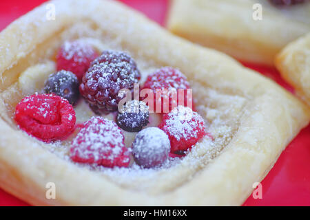 La pâte feuilletée garnie de bleuets frais, framboises et mûres saupoudrée de sucre en poudre Banque D'Images