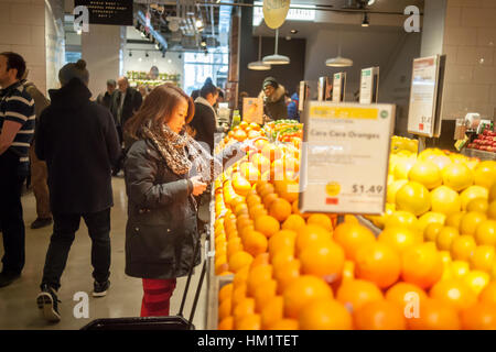 Nouveau client choisit d'oranges dans le nouveau Whole Foods Market en face de Bryant Park à New York le jour de l'ouverture Samedi, 28 janvier 2017. Le magasin dans le centre de Manhattan est la chaîne de 11e magasin pour s'ouvrir dans la ville. Le magasin a une grande sélection d'aliments préparés à partir d'un groupe diversifié de fournisseurs à l'intérieur du magasin. (© Richard B. Levine) Banque D'Images