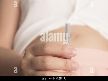 Femme enceinte avec la seringue dans la main ('image filtrée traitées effet vintage. ) Banque D'Images