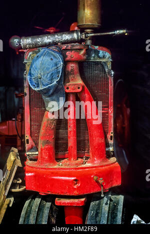 Encore l'agriculture vie de l'extrémité avant d'un antique tracteur rouge avec farmer's bluejean hat et à graisse à Groton, Massachusetts, USA Banque D'Images