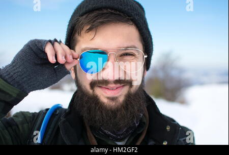 Heureux homme barbu avec des lunettes cassées à l'extérieur Banque D'Images